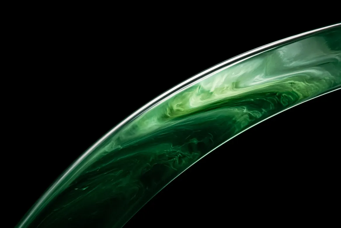 A green glass arc with swirling liquid inside, on black